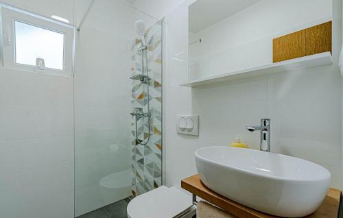 a white bathroom with a sink and a shower at Apartmani Pipin - Prigradica, kod Caffe Tempera in Prigradica