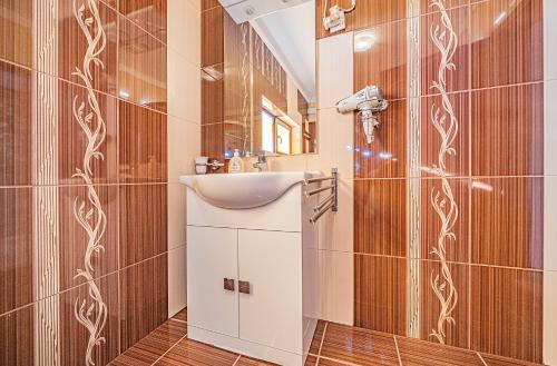 a bathroom with a sink and a mirror at Pension Onix Vienna Airport in Maria Ellend