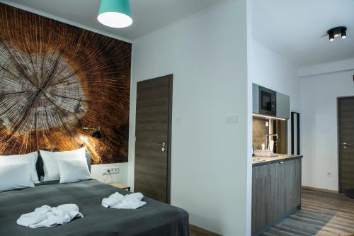 a bedroom with a bed with towels on it at Marusius Apartmanház in Makó