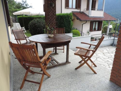 een houten tafel en stoelen op een patio bij Casa Vacanza il Glicine in Casale Corte Cerro