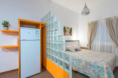 ein Schlafzimmer mit einem Bett und einem Kühlschrank. in der Unterkunft Z45 Loft con Wifi en el Madrid Centro in Madrid