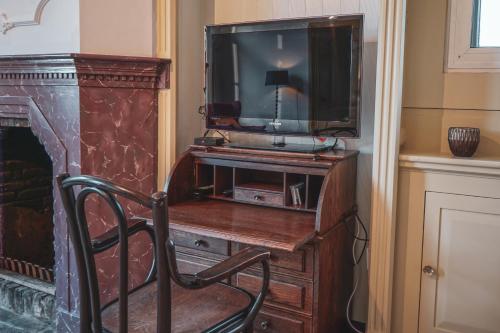 a room with a desk with a tv and a chair at Bed & Breakfast Bloemen Vertellen in Elst