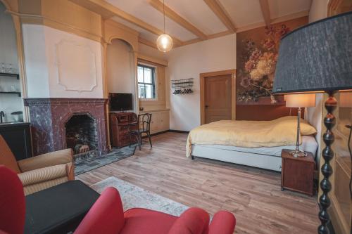 a bedroom with a bed and a fireplace at Bed & Breakfast Bloemen Vertellen in Elst