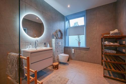 a bathroom with a sink and a mirror at Bed & Breakfast Bloemen Vertellen in Elst