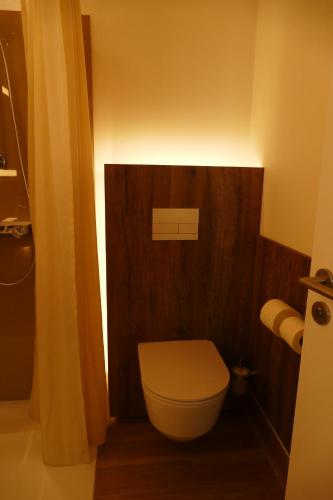 a bathroom with a toilet with a sign above it at Meyn's Apartments & Hotel in Soltau