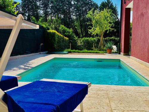 - une piscine avec une table bleue et des chaises à côté d'une maison dans l'établissement DEPENDANCE LAZISE LAGO DI GARDA, à Lazise