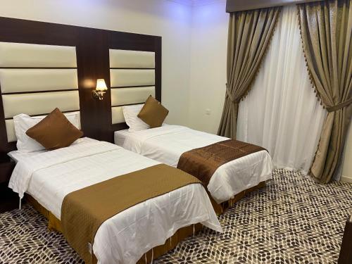 a hotel room with two beds in a room at دانة الشرقية للشقق المخدومة بالدمام Danat Al Sharqiah Serviced Apartments in Dammam