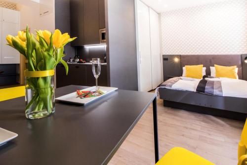 a vase of yellow flowers on a table in a bedroom at In the Hearth of the City Centre, Old Town Square - 3min in Prague