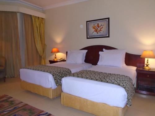 Een bed of bedden in een kamer bij Grand Pyramids Hotel