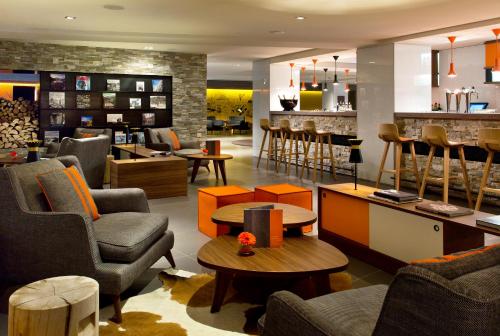 a lobby with chairs and tables and a bar at Heliopic Hotel & Spa in Chamonix