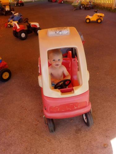 a baby is sitting in a toy car at Landhaus Tirol in Presseggersee