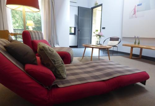 a red couch with a blanket on it in a living room at Jardin de Carrejo in Cabezón de la Sal