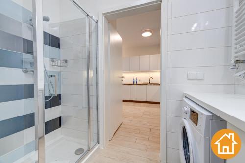 ein Bad mit einer Dusche und einer Waschmaschine in der Unterkunft Apartamenty Aquamarina Onyx - visitopl in Misdroy