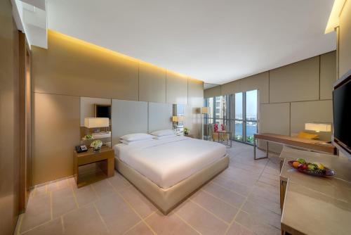 een grote slaapkamer met een bed en een televisie bij Hyatt Regency Creek Heights Residences in Dubai