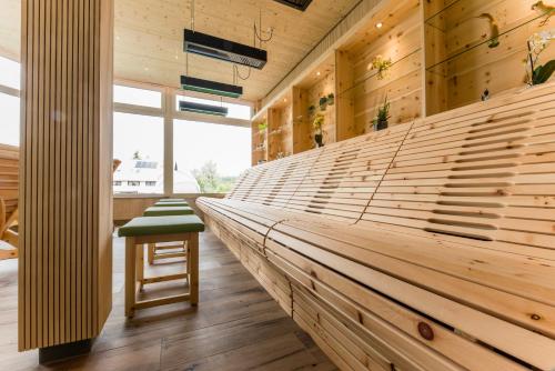 a long wooden bench in a room with a stool at Wellnesshotel Sonnenhof & Sonnhalde in Ühlingen-Birkendorf