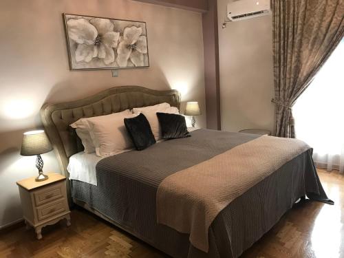 Un dormitorio con una cama grande y una ventana en Denise Luxury Apartment-Centre of Athens,Kolonaki, en Atenas