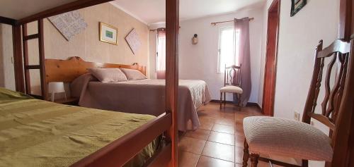a small bedroom with two beds and a window at La Hoyilla Hostel - La Aldea in San Nicolás