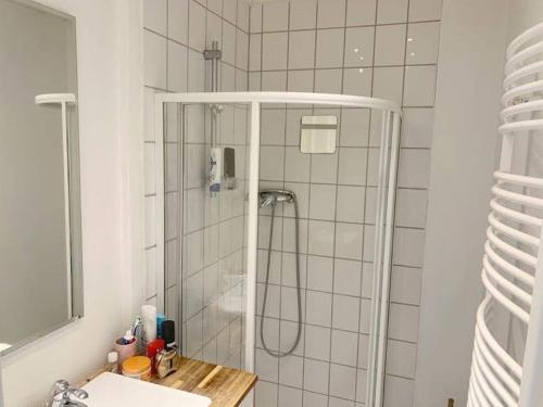菲林根－施文寧根的住宿－Cozy Room in a Sharing Apartment WG in the black forest，带淋浴、水槽和镜子的浴室