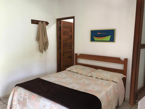 a small bedroom with a bed and a door at Pouso Familiar - Cantinho das Águas in Paraty