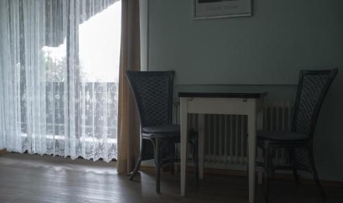 einen Tisch und zwei Stühle in einem Zimmer mit Fenster in der Unterkunft wohnung oben Steiger in Bad Birnbach