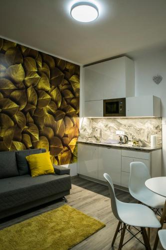 a living room with a couch and a kitchen at Marusius Apartmanház in Makó