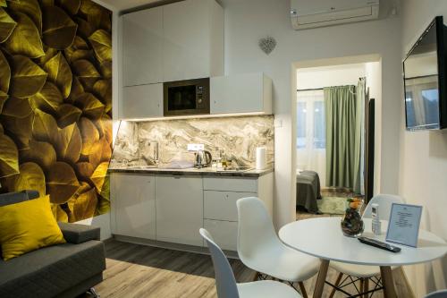 a kitchen and living room with a table and a couch at Marusius Apartmanház in Makó
