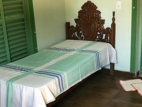 Bett mit einem Kopfteil aus Holz in einem Zimmer in der Unterkunft hospedagem casa da wal quarto suíte in Goiás