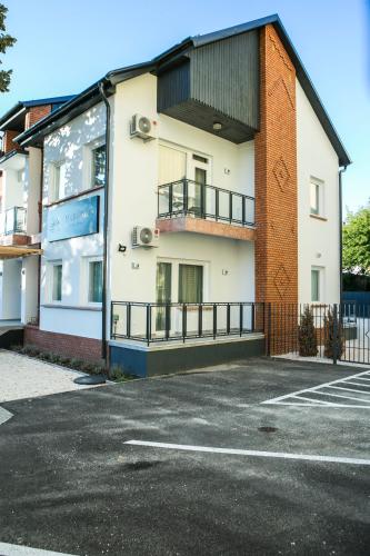 an empty parking lot in front of a building at Marusius Apartmanház in Makó