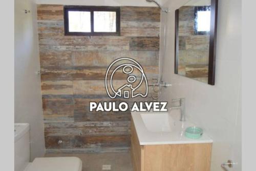 a bathroom with a toilet and a wooden wall at BAHIA SAN FRANCISCO, casa Albatros a 80 metros del mar, Uruguay in Piriápolis