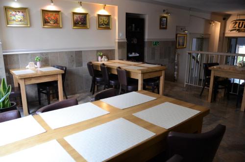 a dining room with wooden tables and chairs at Zajazd Wrota Lasu in Hajnówka