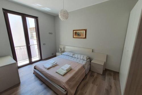 - une chambre avec un lit et 2 serviettes dans l'établissement Appartamento vacanza mare nel centro di Brolo, à Brolo