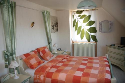 una camera con un letto con una coperta a scacchi e una finestra di Asphodèle ad Ambon