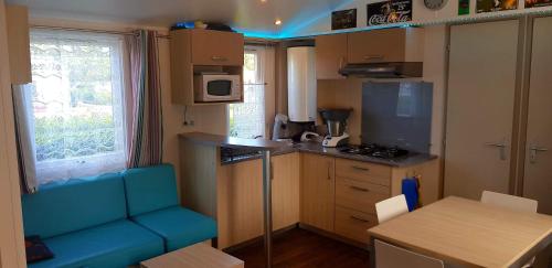 una cucina con divano blu in una piccola cucina di omaha beach home a Colleville-sur-Mer