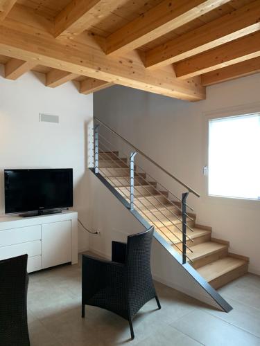 a living room with a staircase and a television at Villavecchia in Castegnero