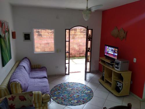 a living room with a couch and a tv at Casacurral in Ilhabela