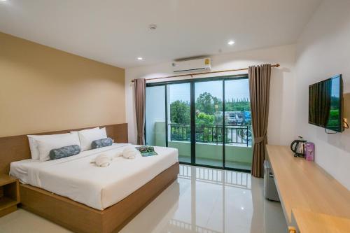 クラビタウンにあるWanarom Residence Hotelの大きなベッドとバルコニーのある寝室