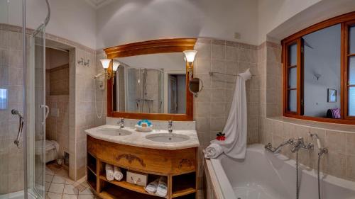 a bathroom with a sink and a tub and a mirror at Hotel Miramar in Opatija
