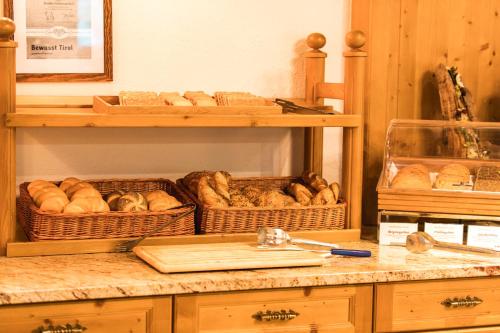 a shelf with baskets of loaves of bread on it at Hotel Eden in Tux