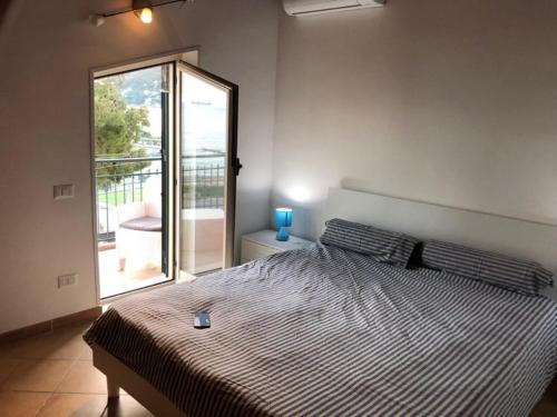 ヴィエトリにあるCasa bella con terrazzo sul mareのベッドルーム1室(大型ベッド1台、スライド式ガラスドア付)
