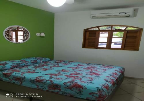 a bedroom with a bed in a room with a window at Casacurral in Ilhabela