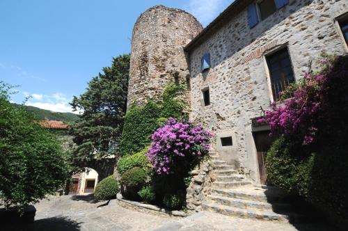 an old stone building with purple flowers and stairs at Amelia Camping in Amélie-les-Bains-Palalda