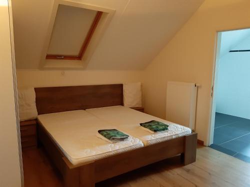 a small bedroom with a bed with two green sheets at Lemen huis Houwaart in Tielt