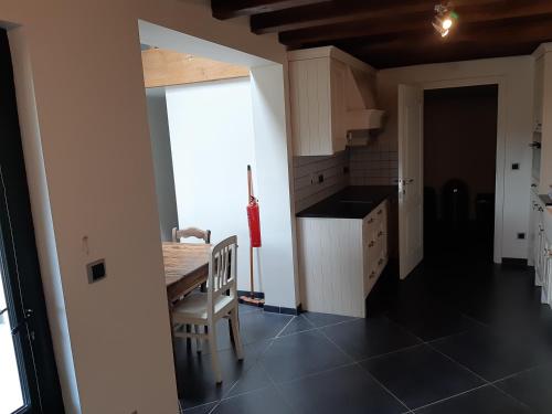 a kitchen with a table and a chair in a room at Lemen huis Houwaart in Tielt