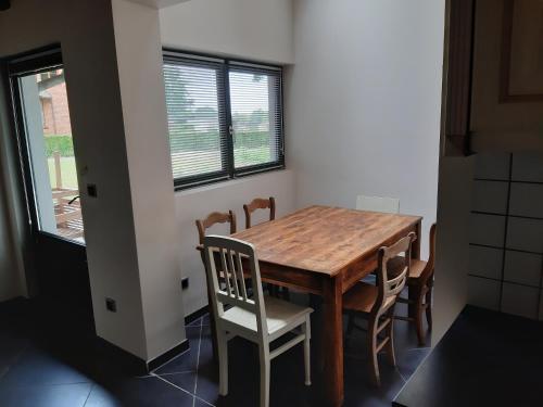 a dining room table and chairs in a room at Lemen huis Houwaart in Tielt