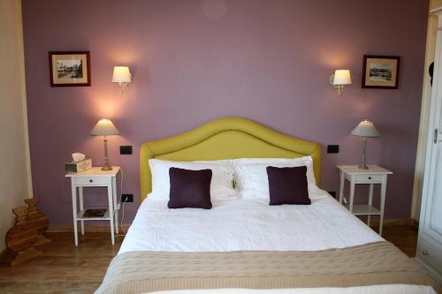 a bedroom with a bed with a yellow headboard and two tables at La Terrazza di Reggello in Reggello