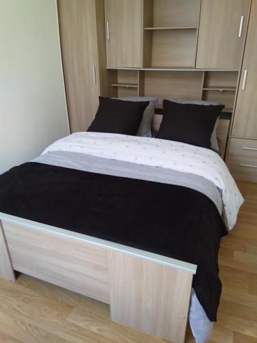 - un grand lit dans une petite pièce avec des armoires dans l'établissement Nid Douillet, à Rochefort