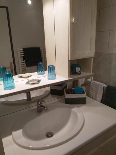 un comptoir de salle de bain avec un lavabo et un miroir dans l'établissement Nid Douillet, à Rochefort