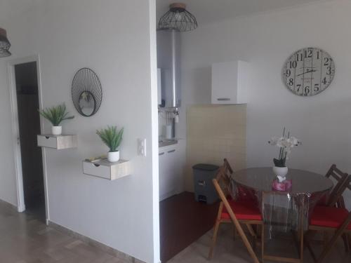 une salle à manger avec une table et une horloge au mur dans l'établissement BRILOC Appartement Route des îles Sanguinaires, à Ajaccio