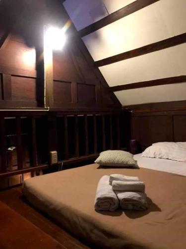 a bedroom with two towels sitting on a bed at นิทานคำกลอน 2 Nithankumkon 2 in Amphawa