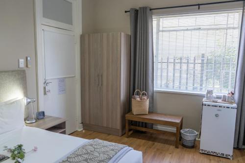 a bedroom with a bed and a large window at De Akker Guest House Oudtshoorn in Oudtshoorn